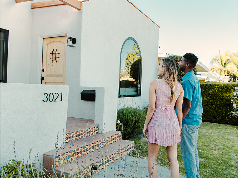 A family standing in front of a home. 